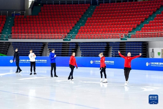 在长春五环体育馆,参加第三届中俄冬季青少年运动会的俄罗斯花样滑冰运动员在赛前场地适应性训练时向场边的中国运动员致意(2022年12月15日摄)。新华社记者 许畅 摄