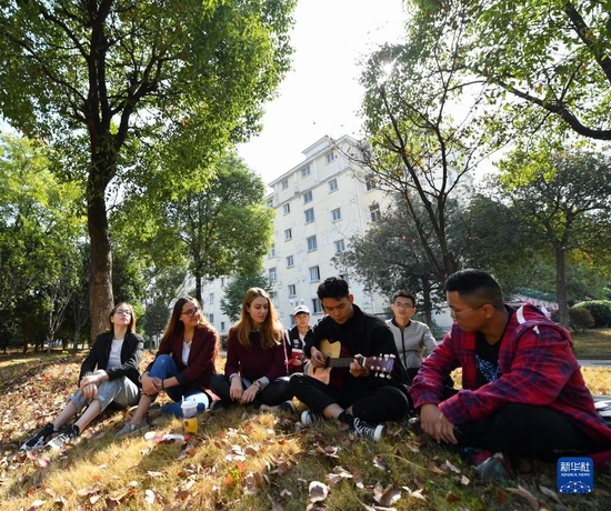 作为中俄交换生在江西省华东交通大学就读的俄罗斯姑娘米卡科娃·娜塔莉亚(左三)在学校欣赏同学弹奏(2019年10月31日摄)。新华社记者 胡晨欢 摄